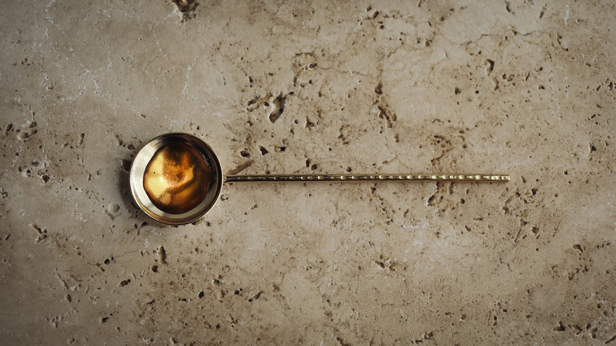 amber elixier oil in a brass spoon
