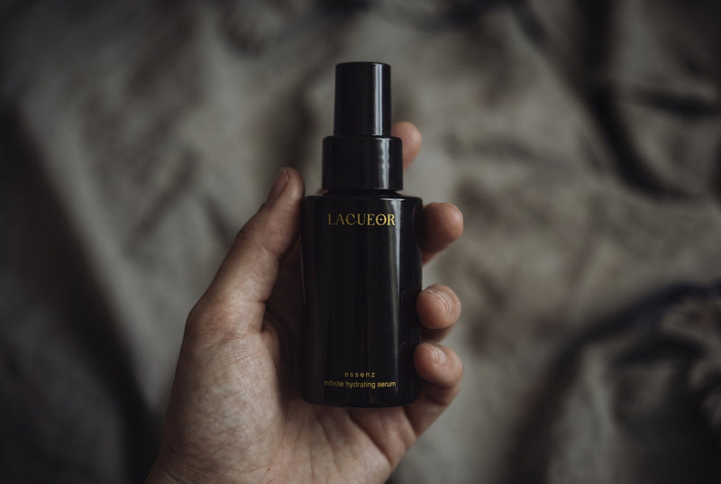 Essenz Serum, Flasche in der Hand auf Leinen