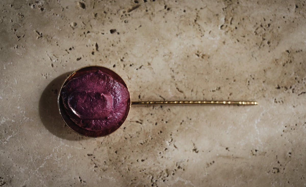 violet staub mask in a brass spoon