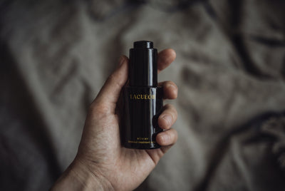 Elixier Serum, Flasche in der Hand auf Leinen