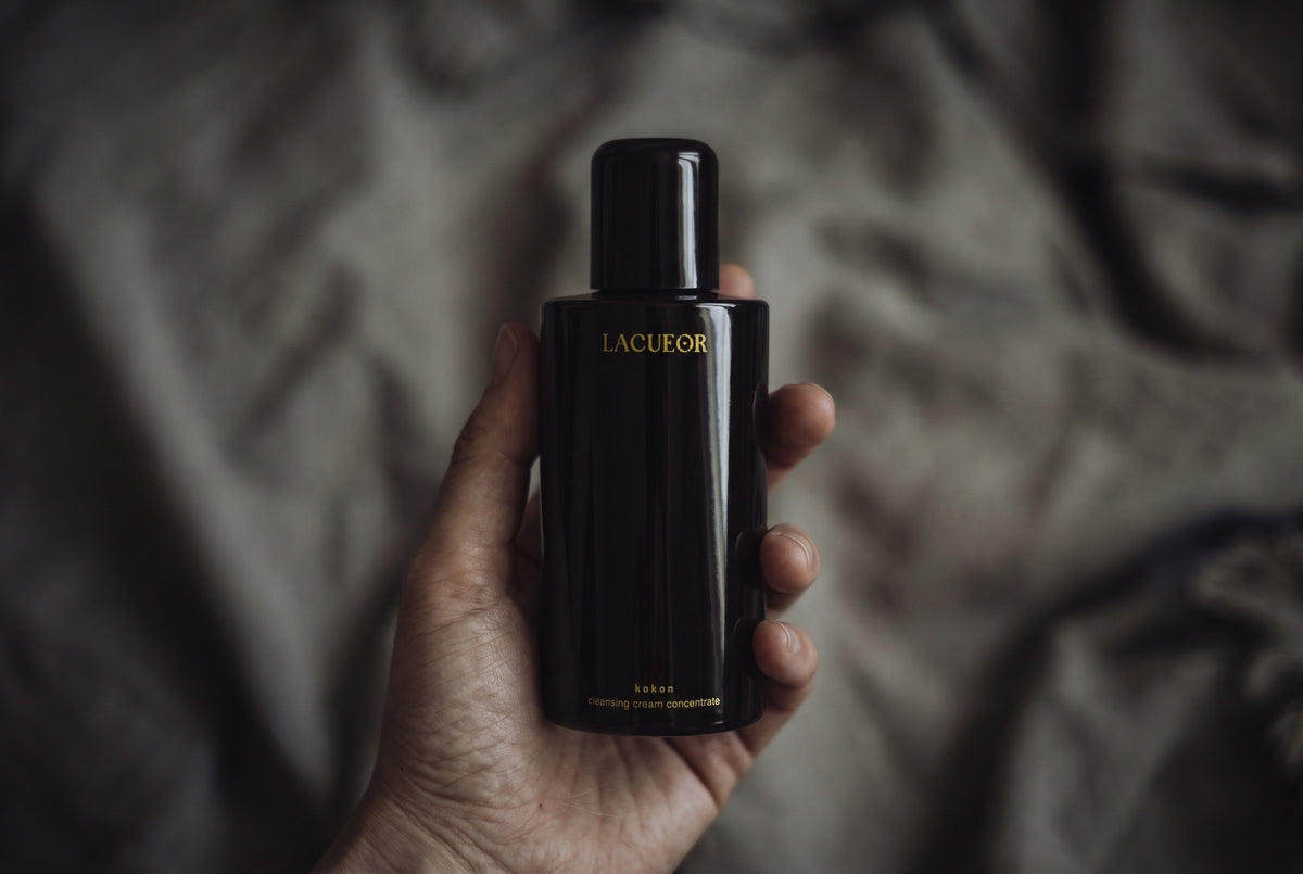 Kokon Reinigungscreme-Konzentrat, Flasche in der Hand auf Leinen