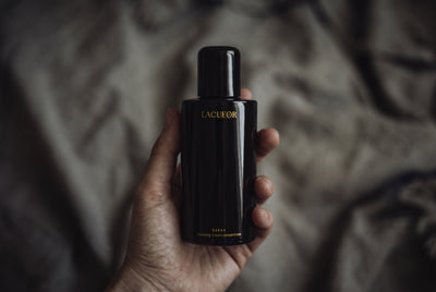 Kokon Reinigungscreme-Konzentrat, Flasche in der Hand auf Leinen