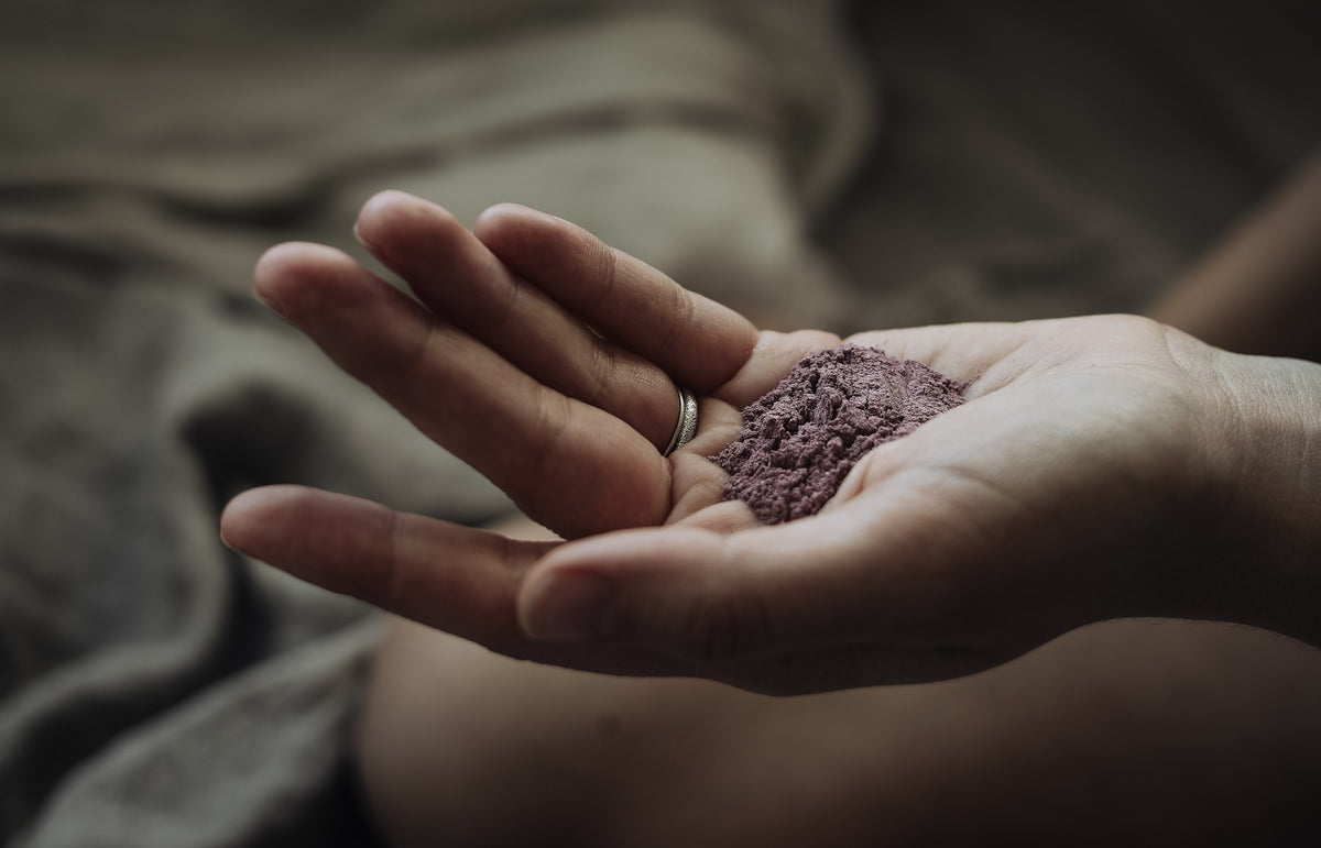 Staub, violettes Pulver in der Handfläche